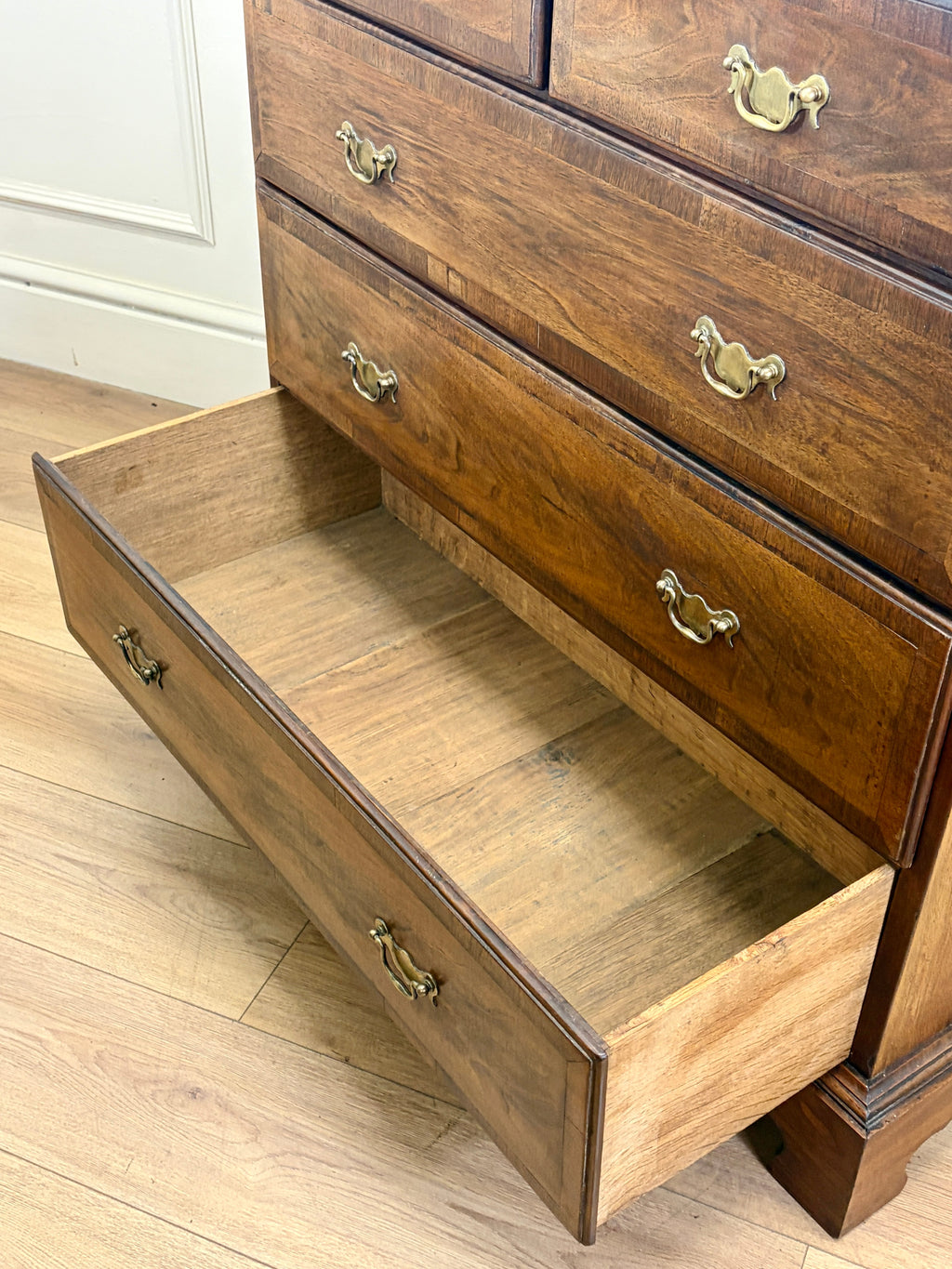 Wooden dresser with open drawer on a wooden floor