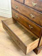 Wooden dresser with open drawer on a wooden floor