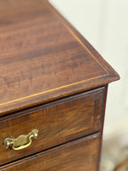 Close-up of a wooden dresser with a brass handle on a blurred background