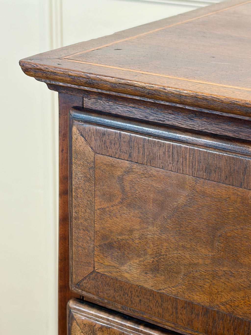 Close-up of a wooden desk with a focus on the corner and top.
