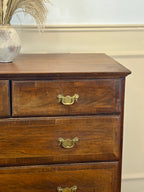 Wooden dresser with brass handles on a neutral background