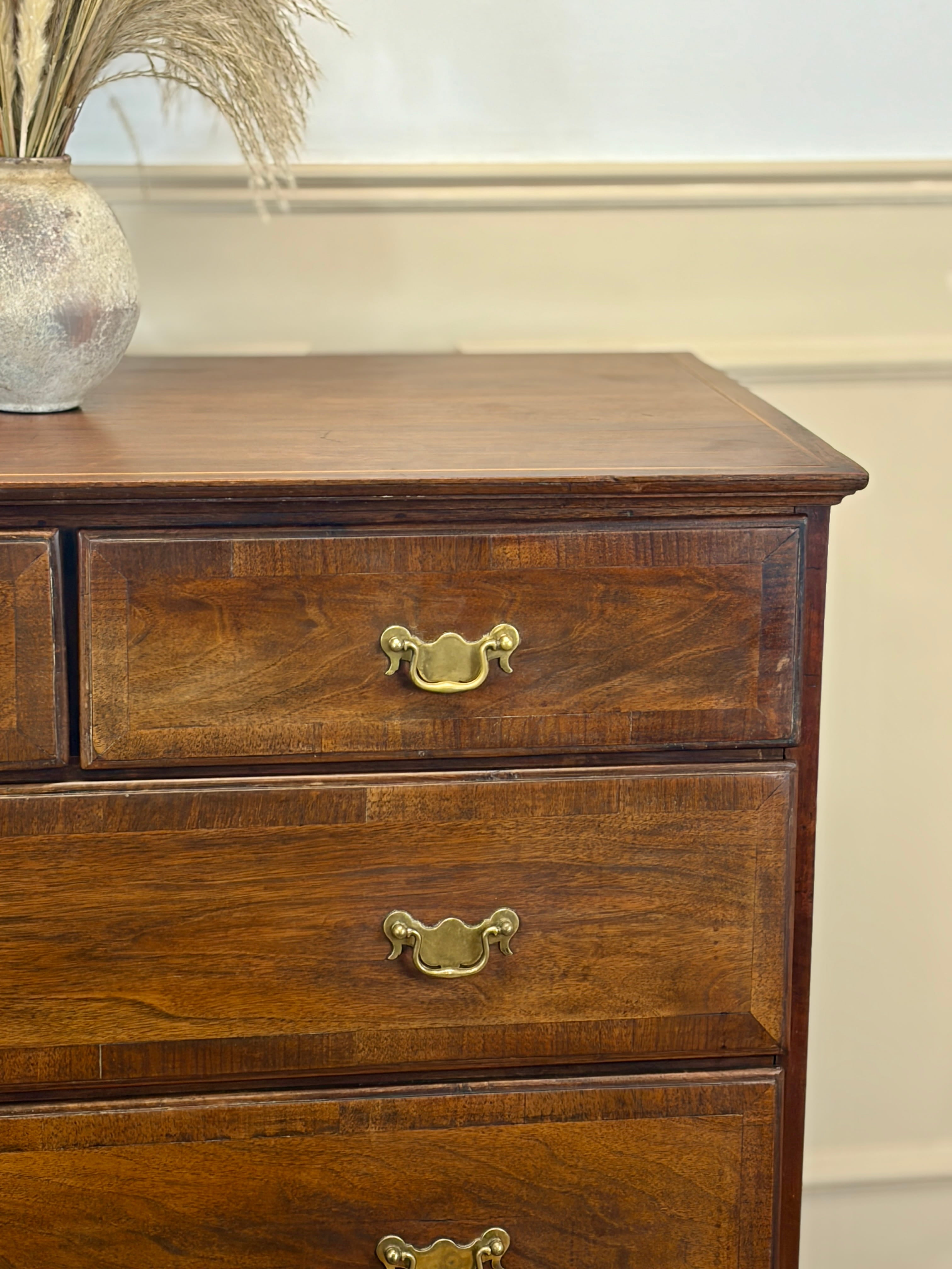 Wooden dresser with brass handles on a neutral background