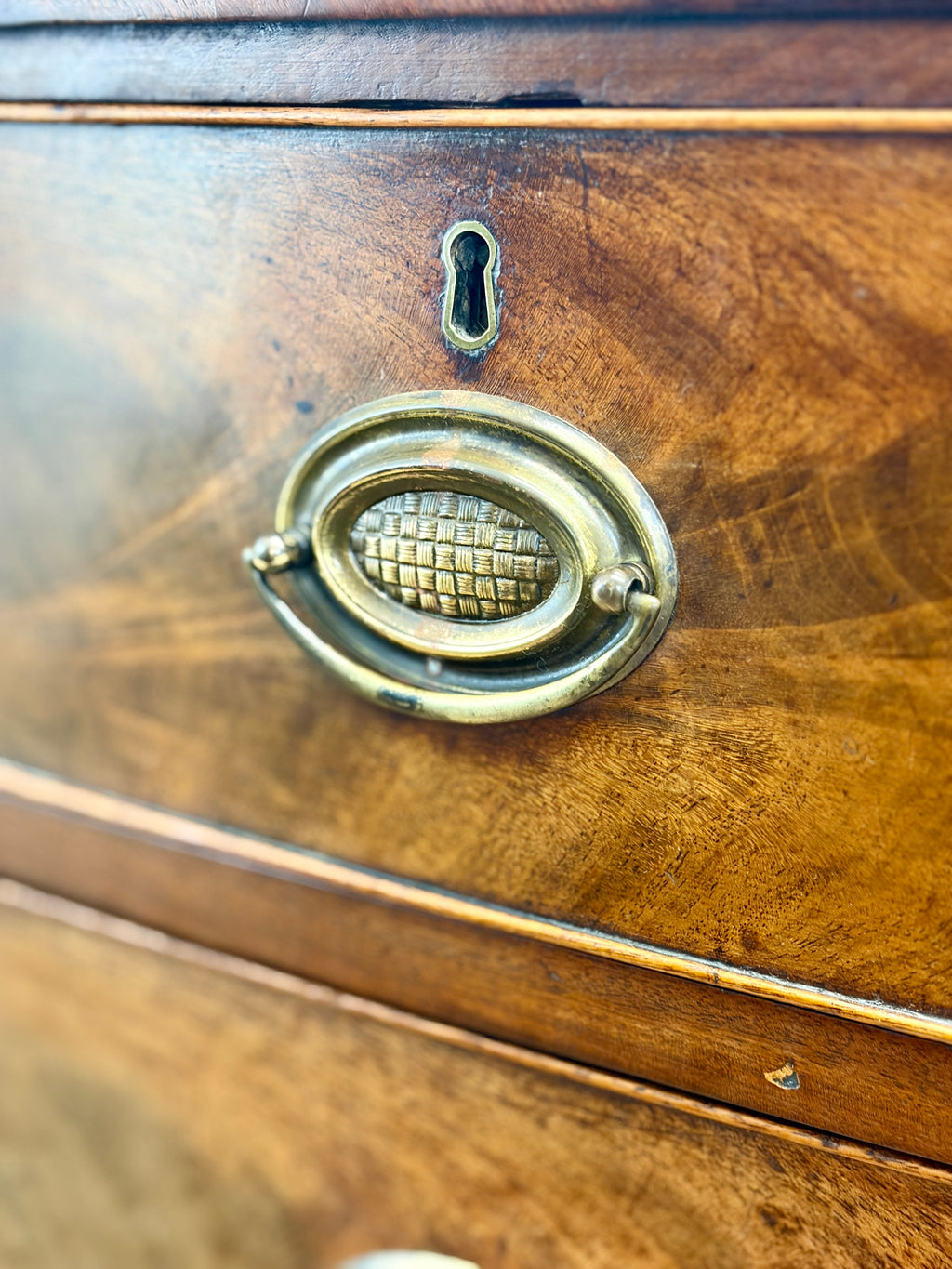 Close-up of a wooden drawer with a brass handle