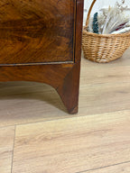 Wooden furniture corner on a wooden floor with a wicker basket in the background.