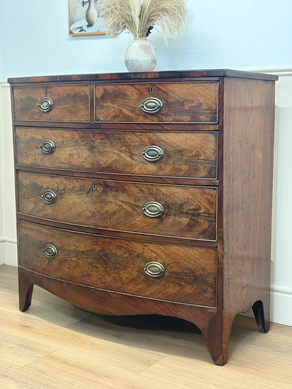Wooden dresser with four drawers in a room setting