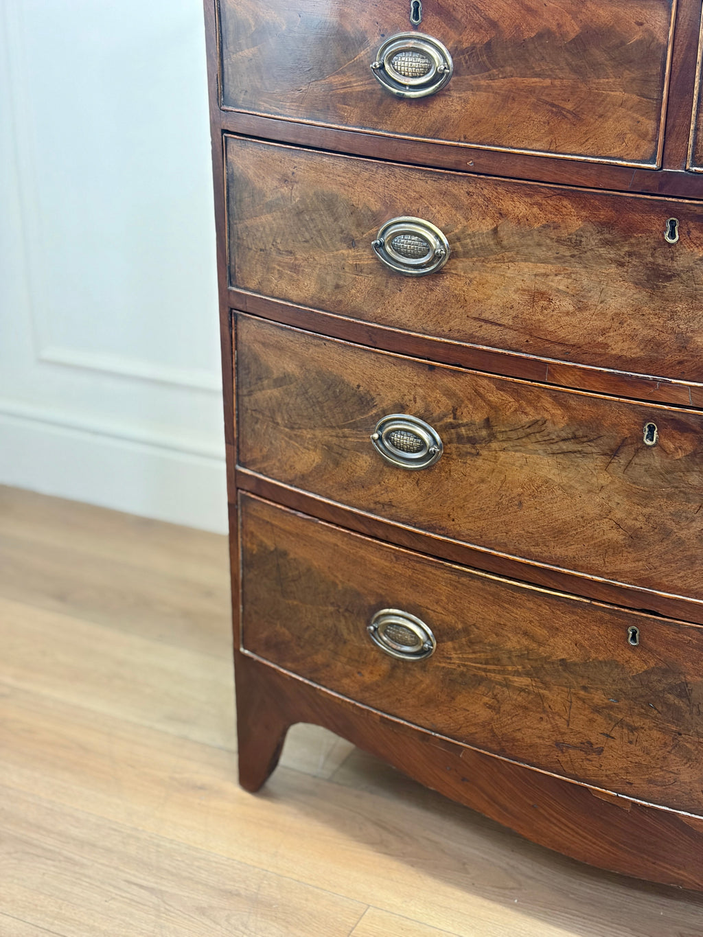 Wooden dresser with four drawers on a wooden floor.