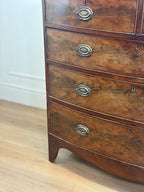 Wooden dresser with four drawers on a wooden floor.