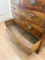 Wooden dresser with open drawer on a wooden floor