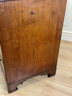 Wooden cabinet with a visible crack on a wooden floor