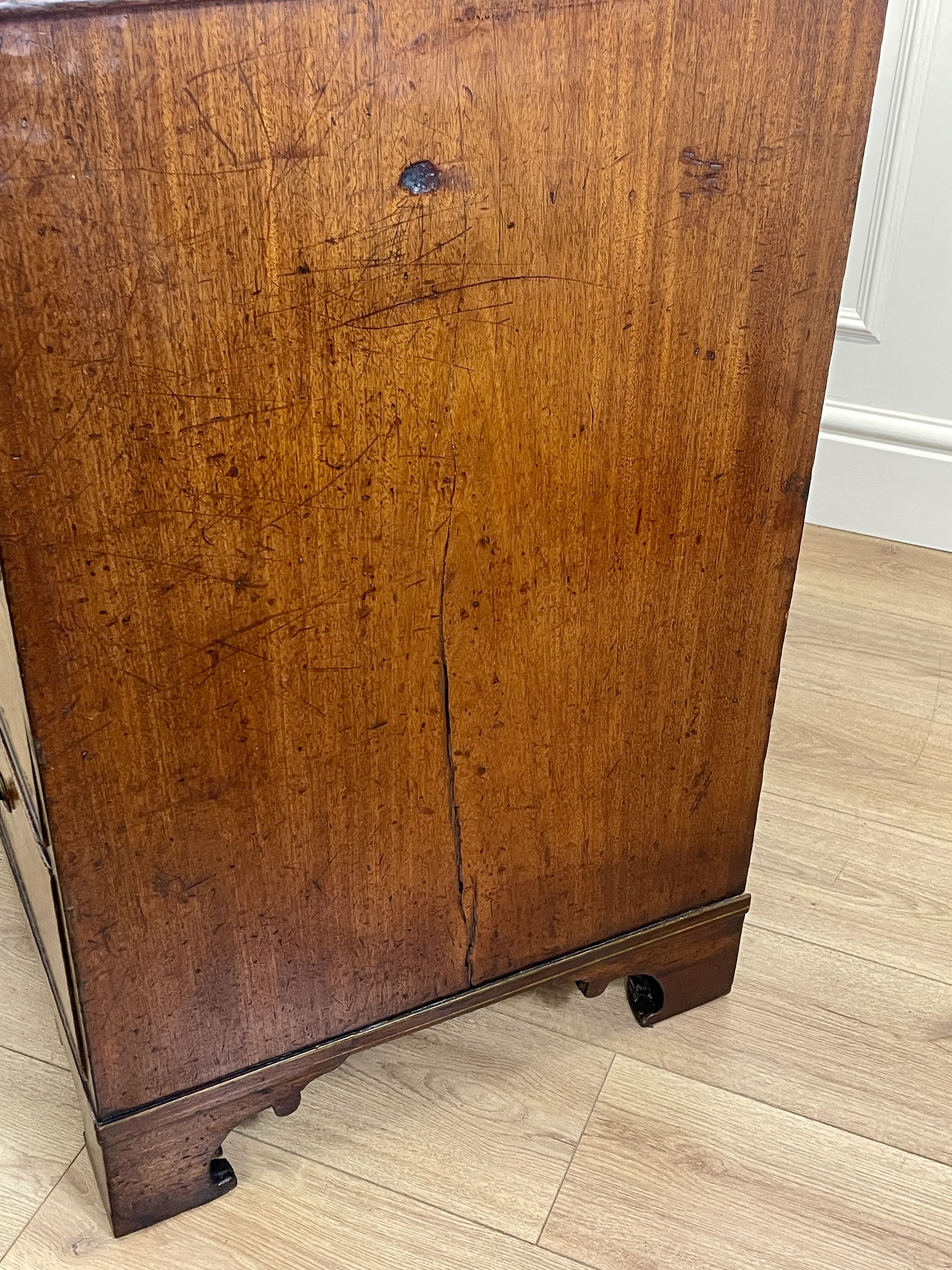 Wooden cabinet with a visible crack on a wooden floor