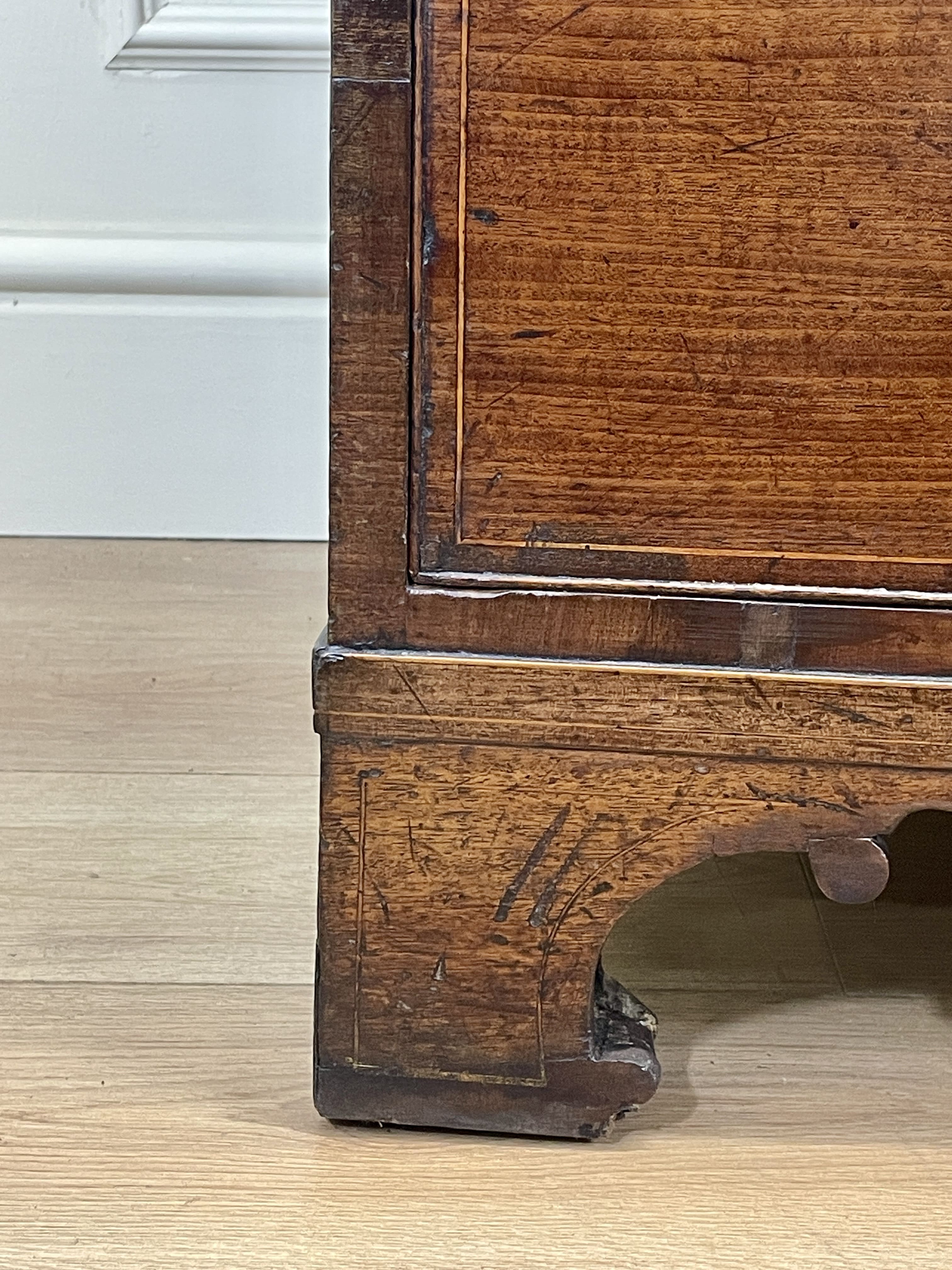 Close-up of a wooden cabinet leg on a light wood floor.