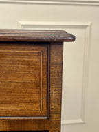Close-up of a wooden cabinet corner with a white wall background
