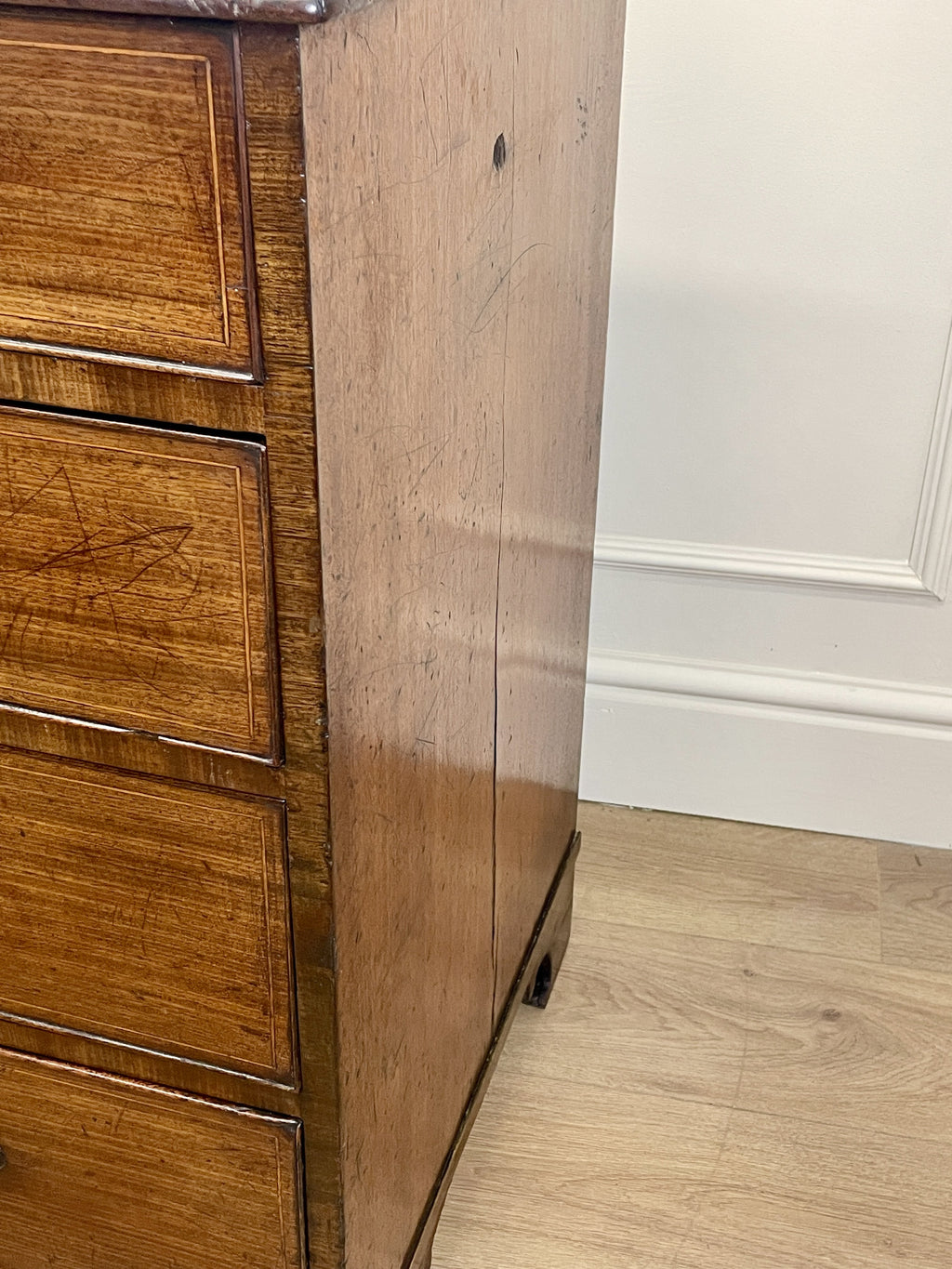Wooden cabinet with a white wall and floor in the background