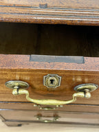 Wooden drawer with brass handle and lock on a wooden surface