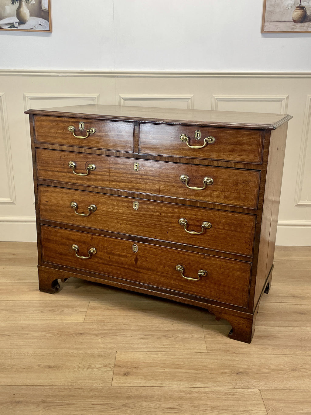 Wooden dresser with multiple drawers on a wooden floor.
