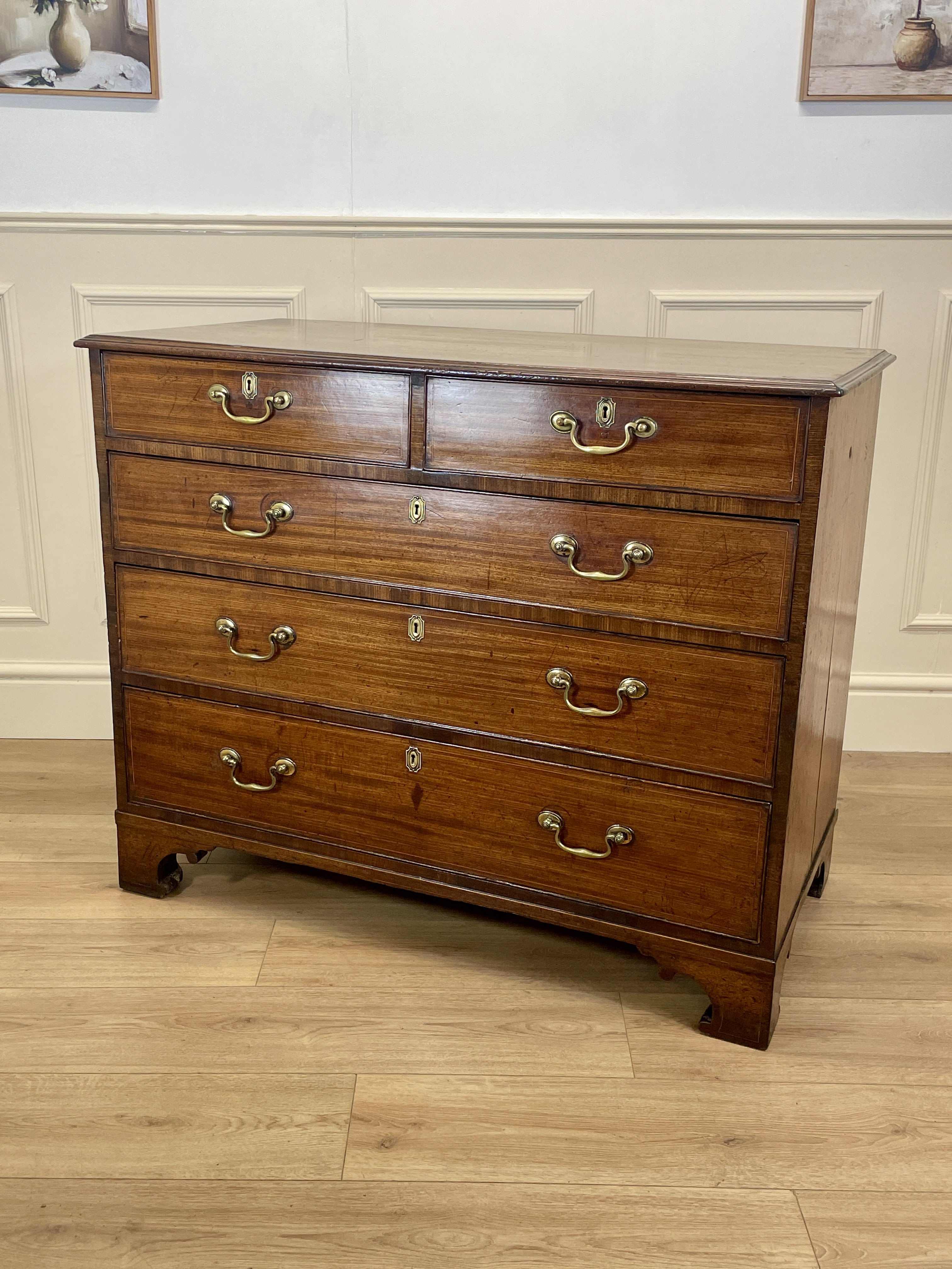 Wooden dresser with multiple drawers on a wooden floor.
