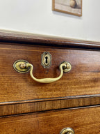 Wooden drawer with brass handle and keyhole on a white wall background