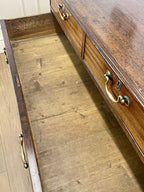 Wooden desk with open drawer showing wear and tear