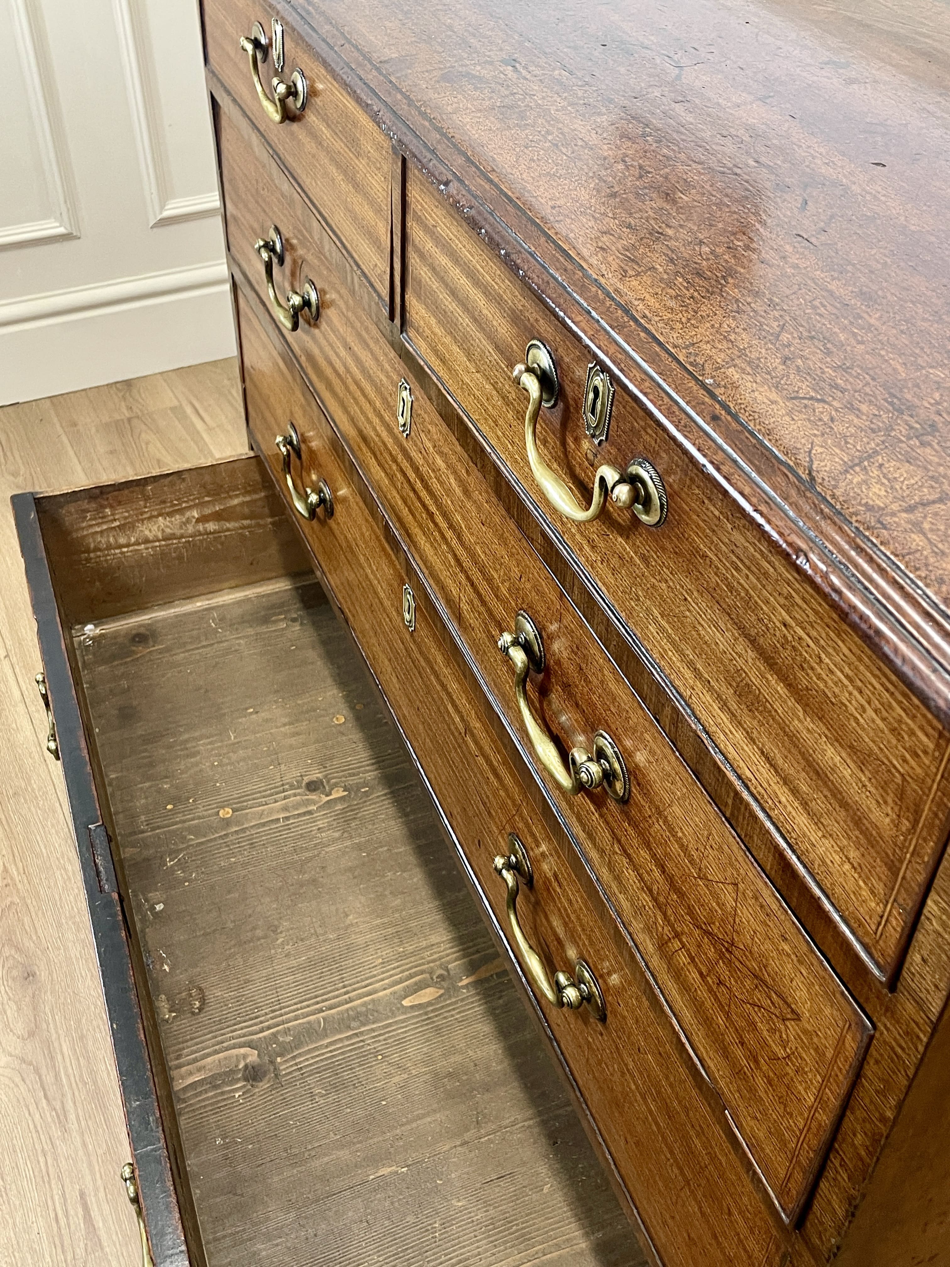Wooden dresser with open drawer on a wooden floor
