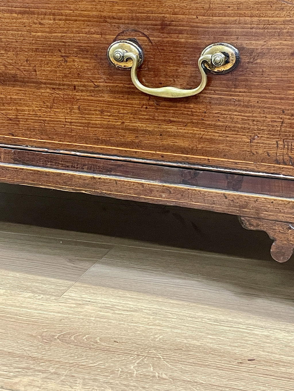 Wooden drawer with brass handle on a wooden floor
