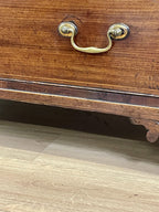 Wooden drawer with brass handle on a wooden floor