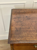 Close-up of a wooden desk with a white wall background
