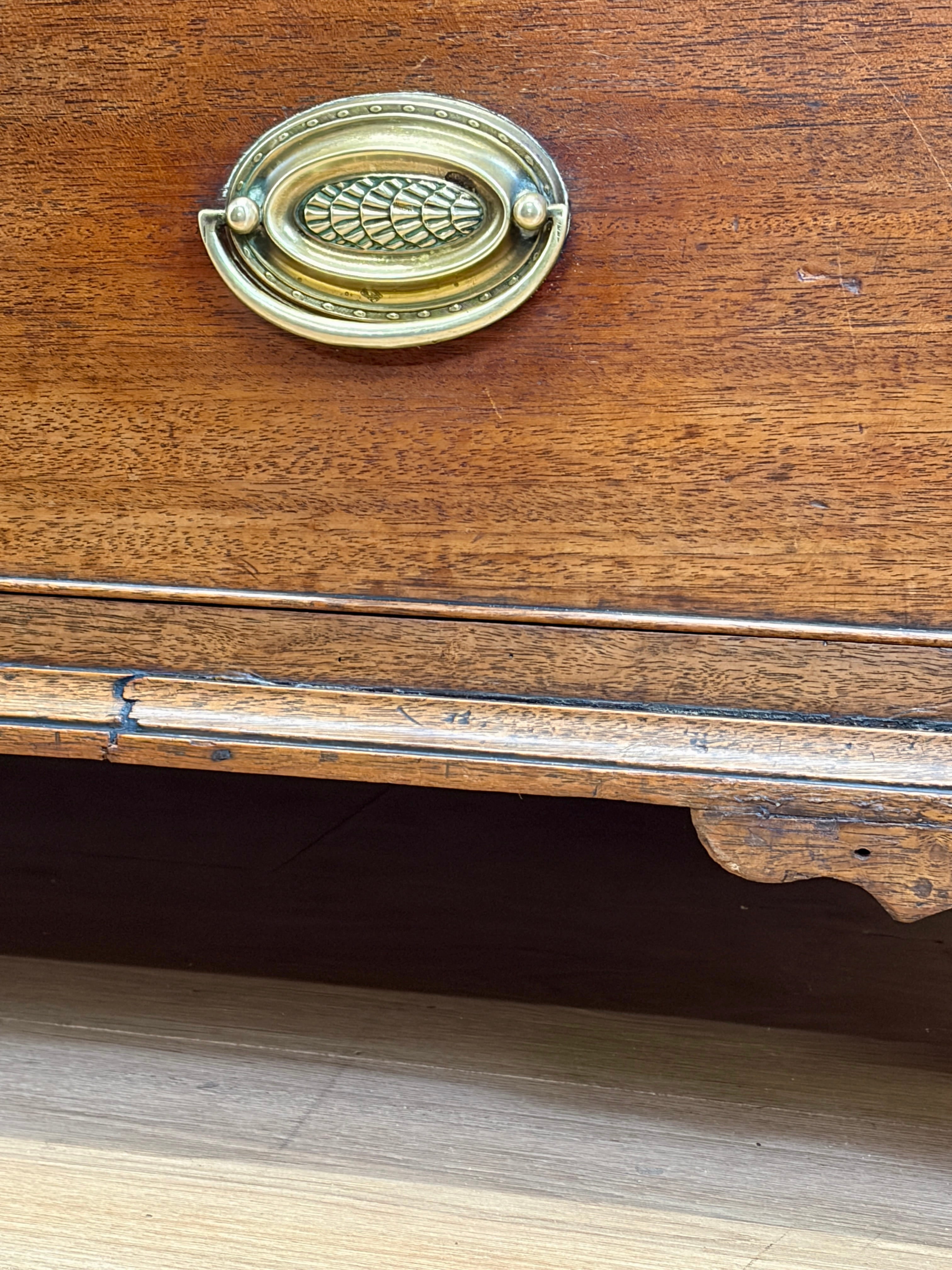 Close-up of a wooden drawer with a brass handle
