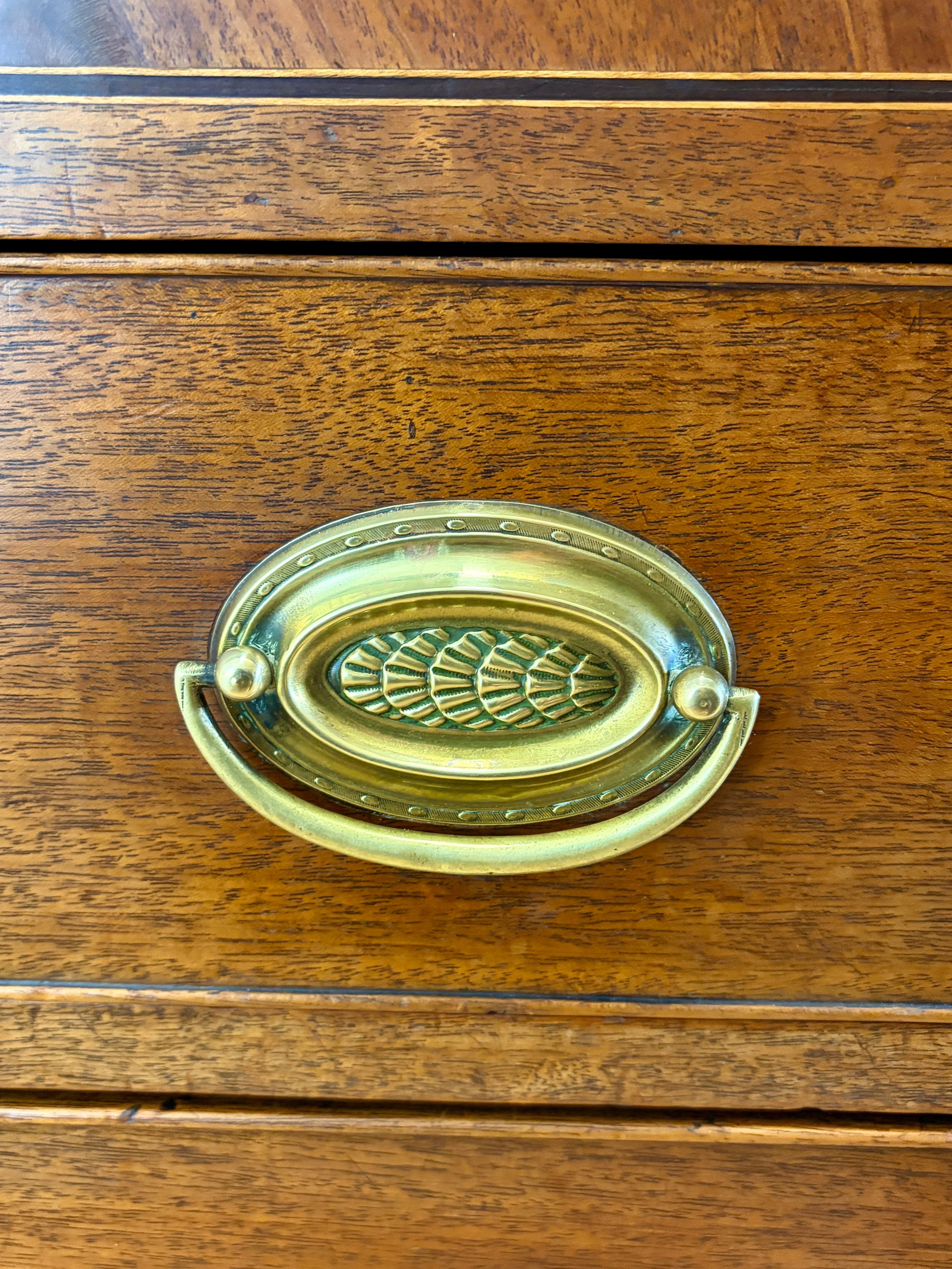 Brass oval handle on a wooden drawer