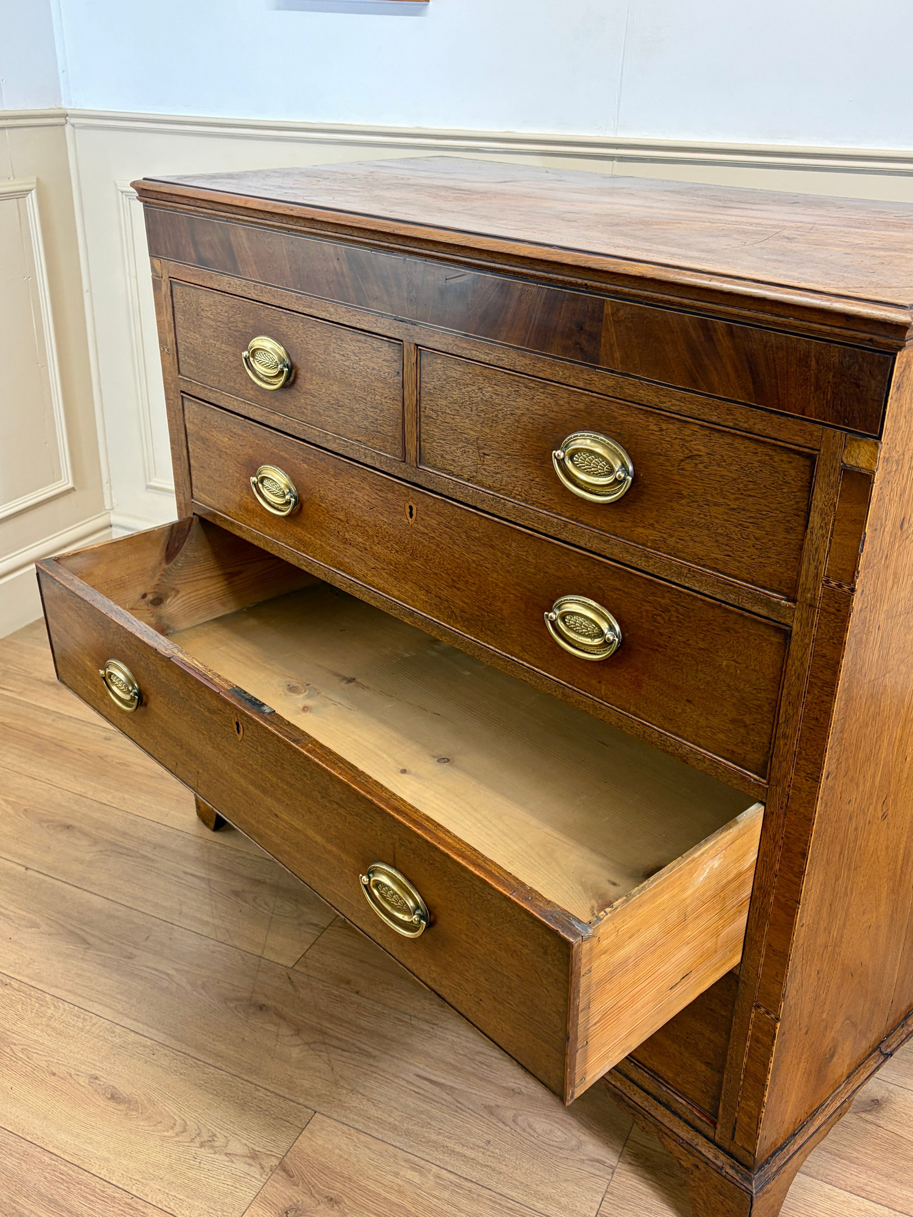 Wooden dresser with open drawer on a wooden floor