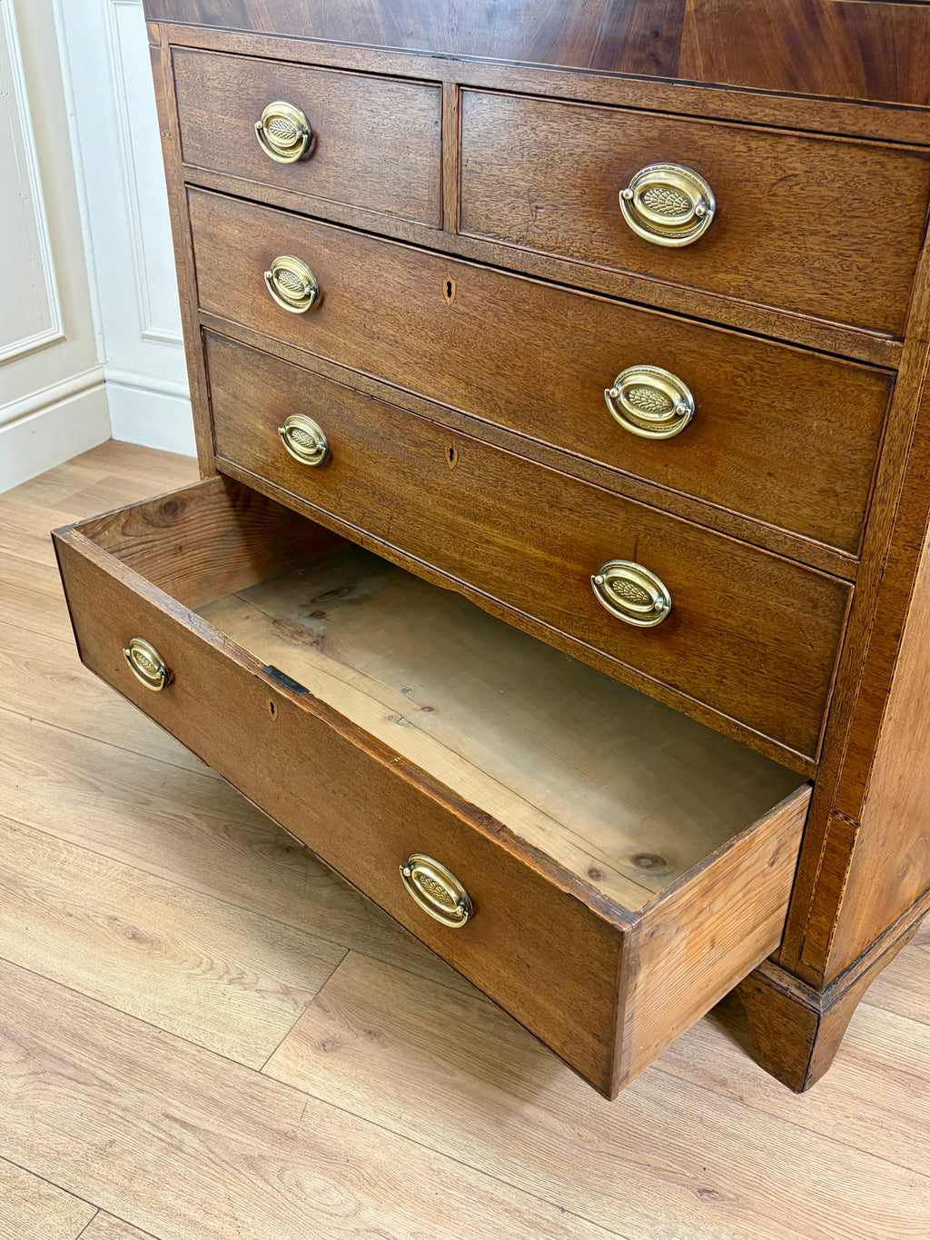 Wooden dresser with open drawer on a wooden floor