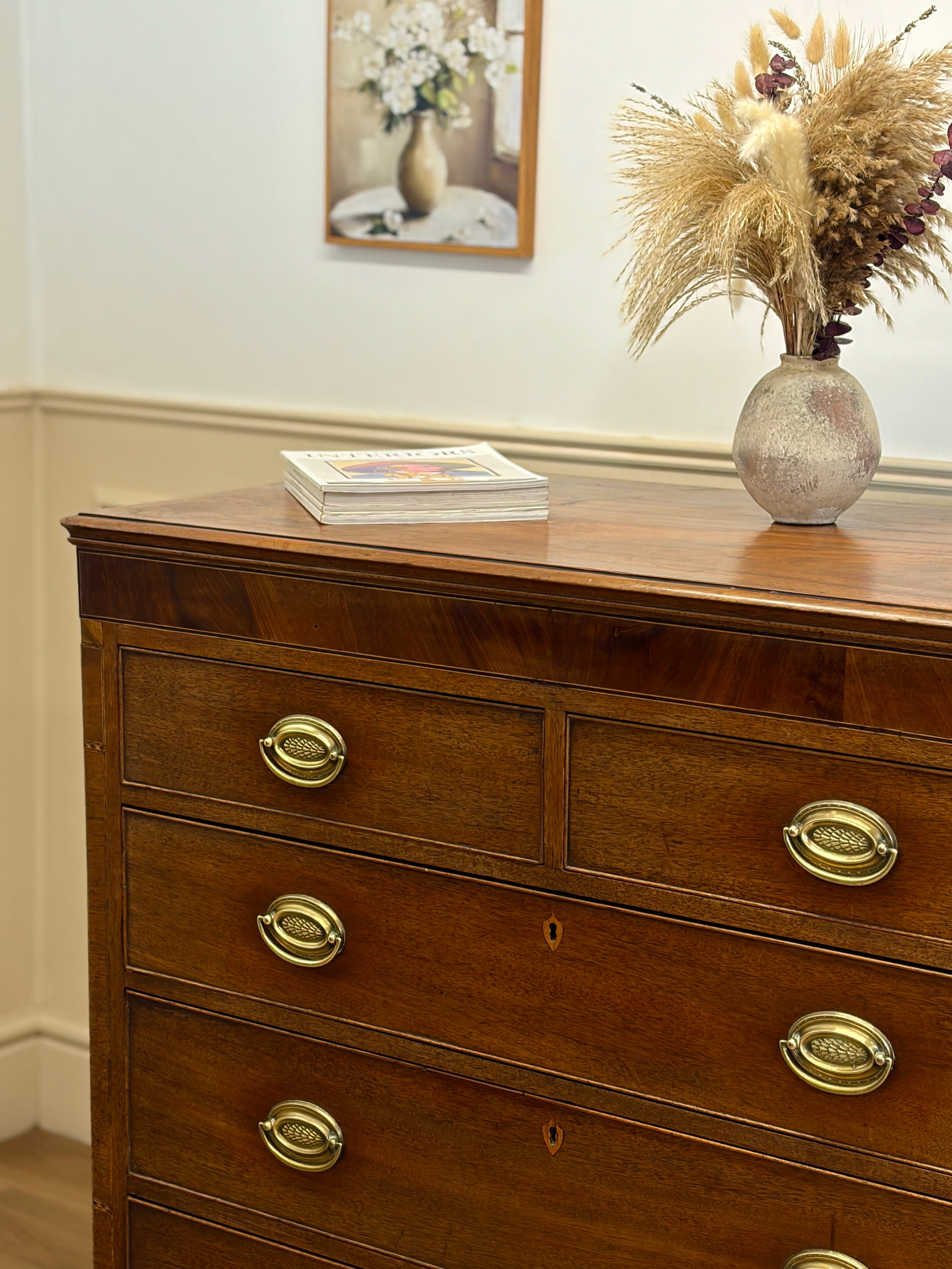 Wooden dresser with brass handles in a room setting