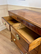 Wooden dresser with open drawer on a wooden floor.