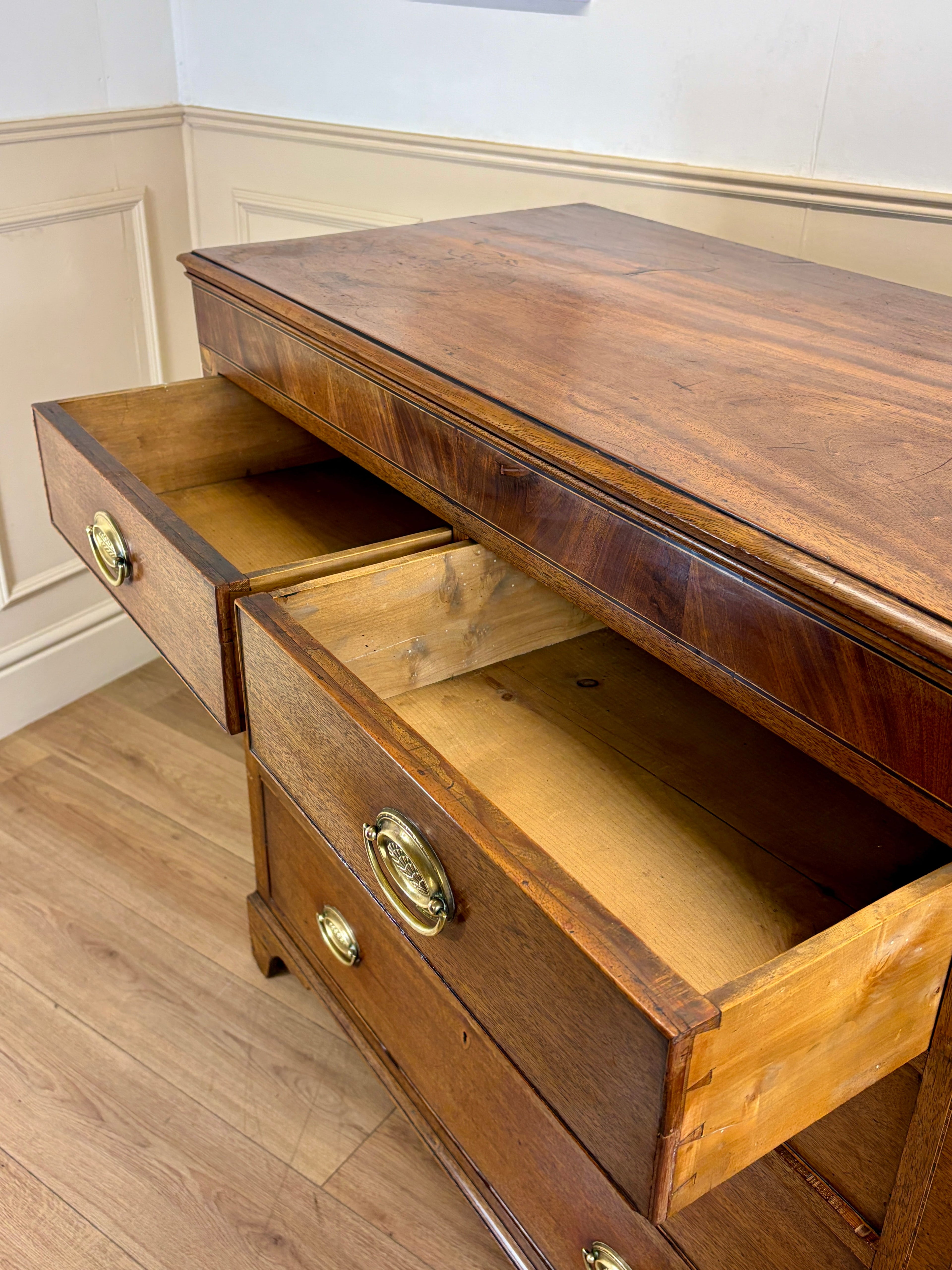 Wooden dresser with open drawer on a wooden floor.