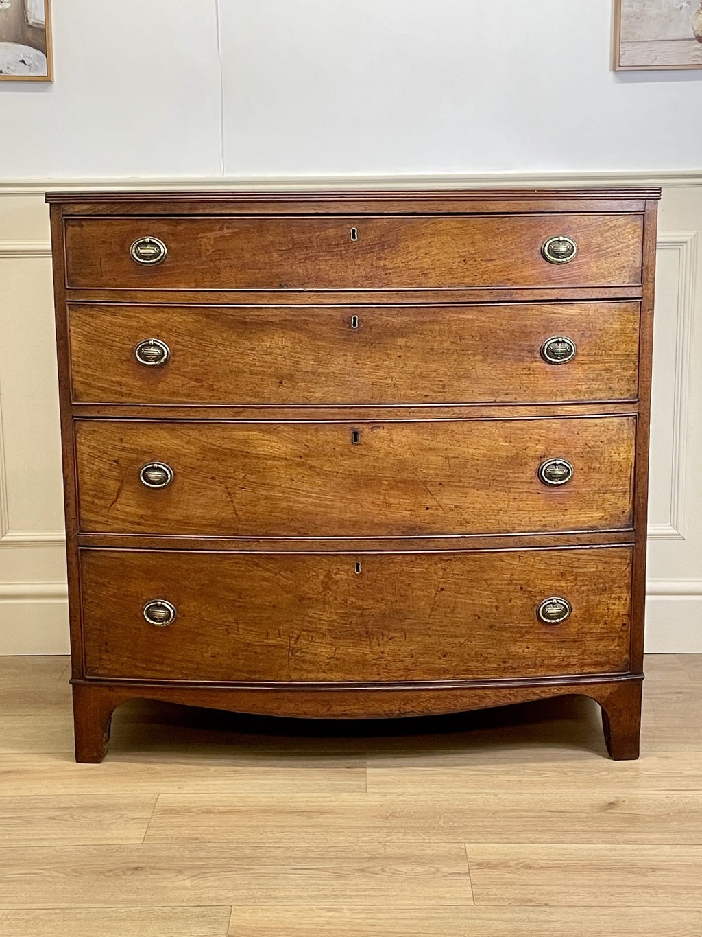 Wooden dresser with four drawers on a wooden floor.