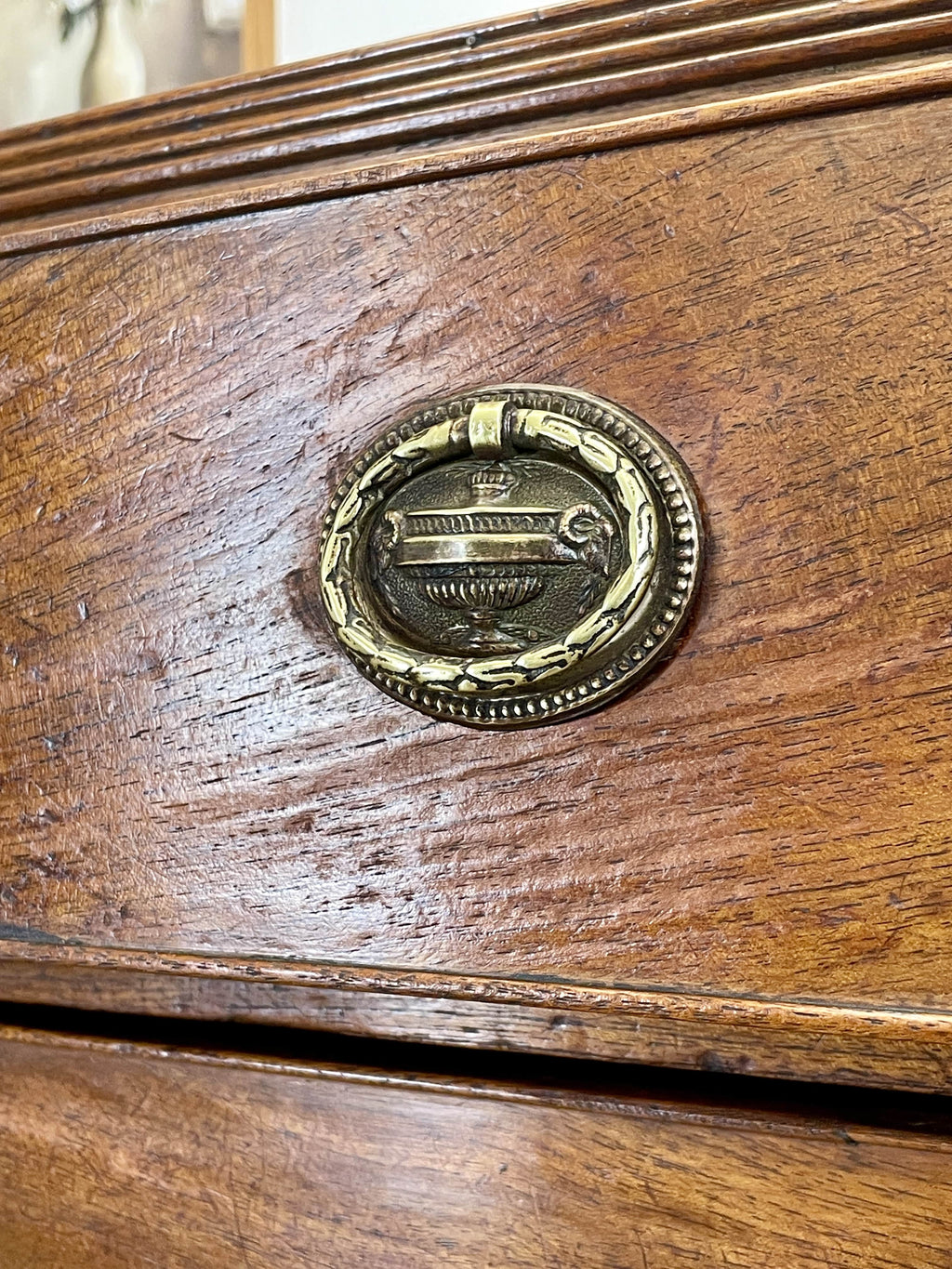 Close-up of a wooden surface with a brass decorative emblem.