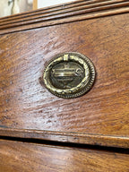 Close-up of a wooden surface with a brass decorative emblem.