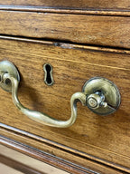 Close-up of a wooden drawer with brass handles and keyhole.