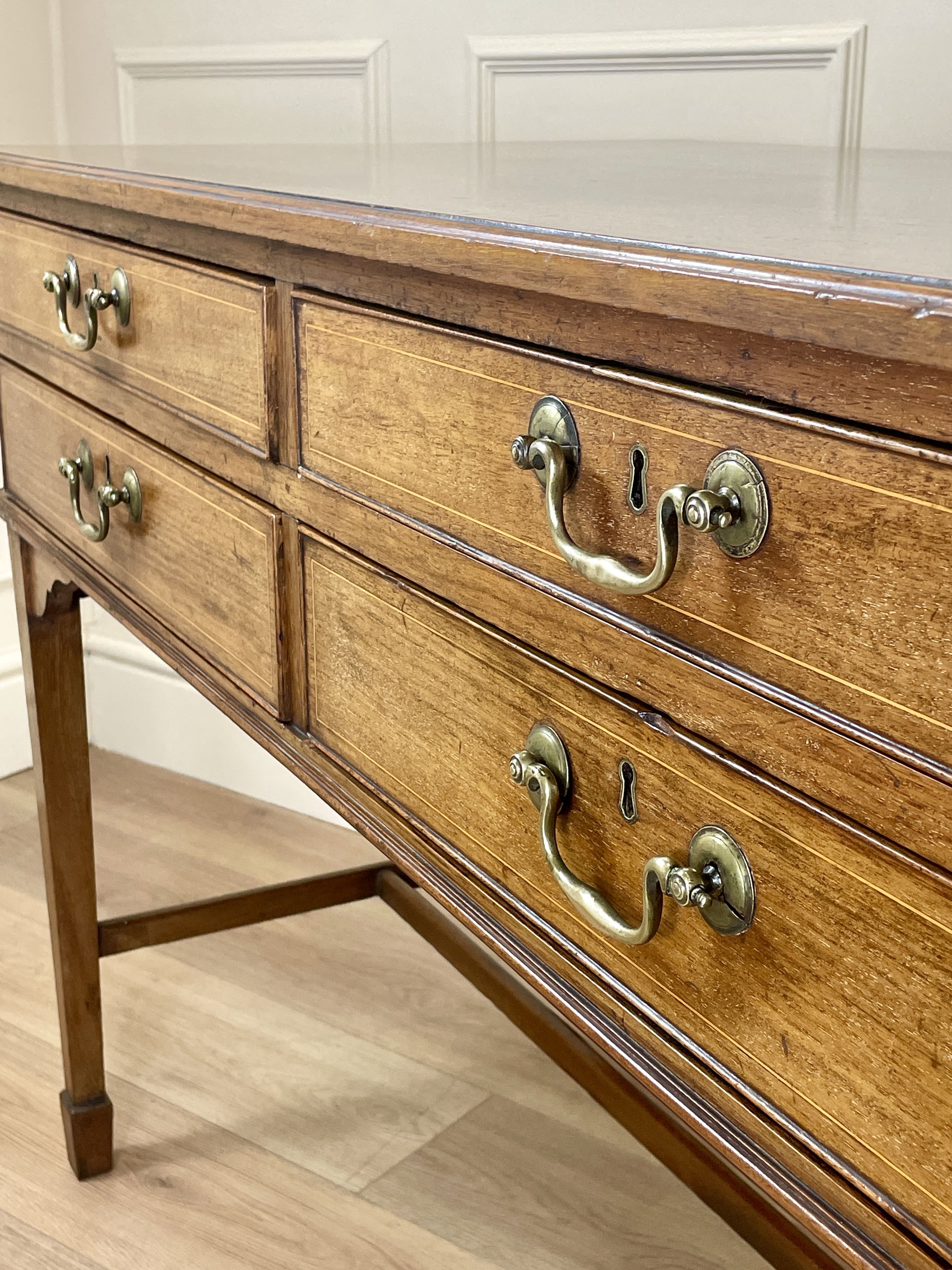 Wooden dresser with brass handles in a room setting