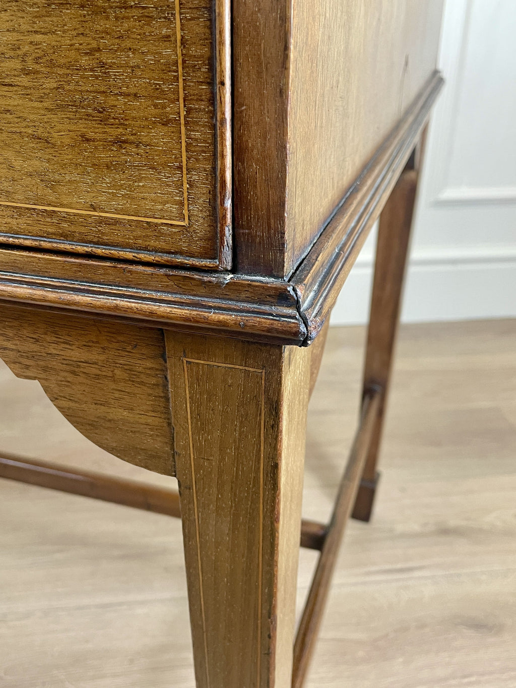Close-up of a wooden desk corner with a white wall background