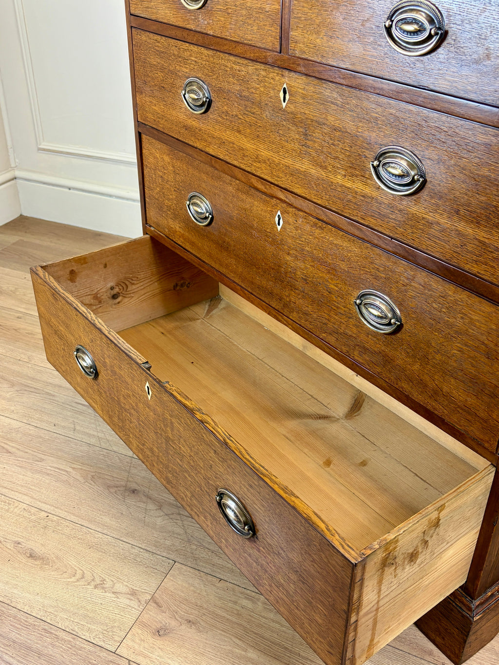 Wooden dresser with an open drawer on a wooden floor