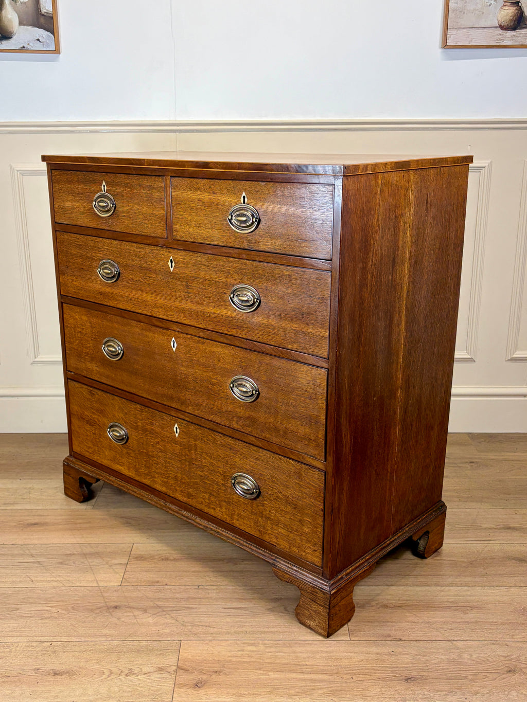 Wooden dresser with four drawers on a wooden floor.
