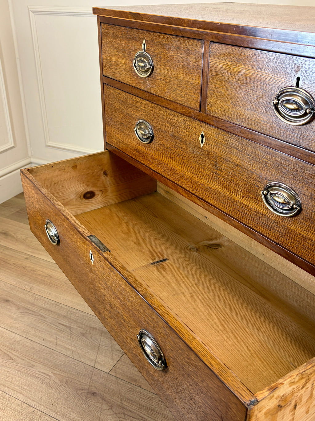 Wooden dresser with open drawer on a wooden floor
