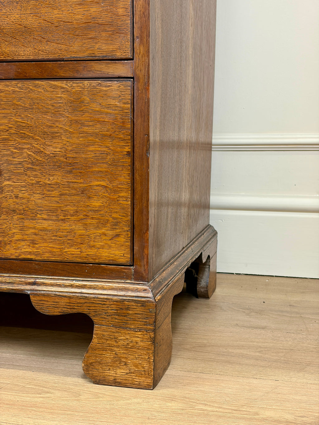 Wooden cabinet with a white baseboard in the background