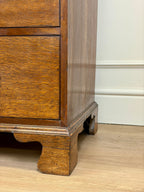 Wooden cabinet with a white baseboard in the background