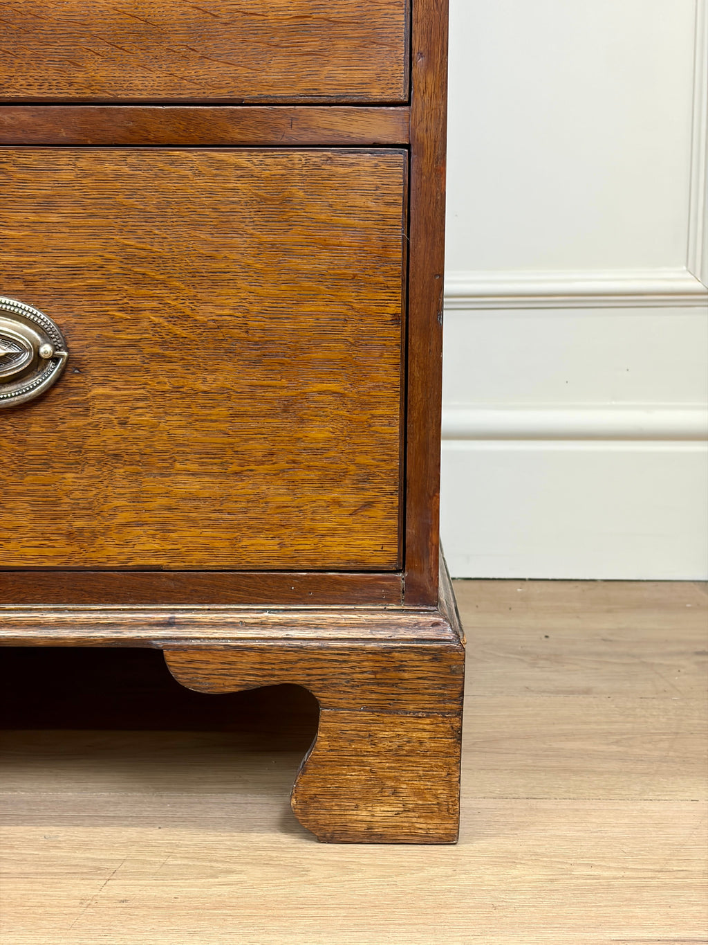 Wooden drawer with a metal handle on a wooden floor.