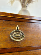 Close-up of a wooden drawer with a brass handle and keyhole.