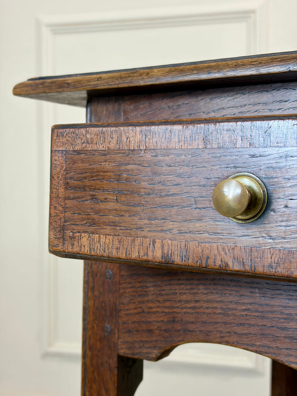 Close-up of a wooden drawer with a brass handle on a white background
