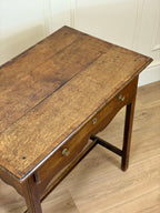 Wooden table with a rustic finish on a wooden floor.