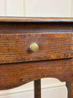 Close-up of a wooden drawer with a brass knob against a white background