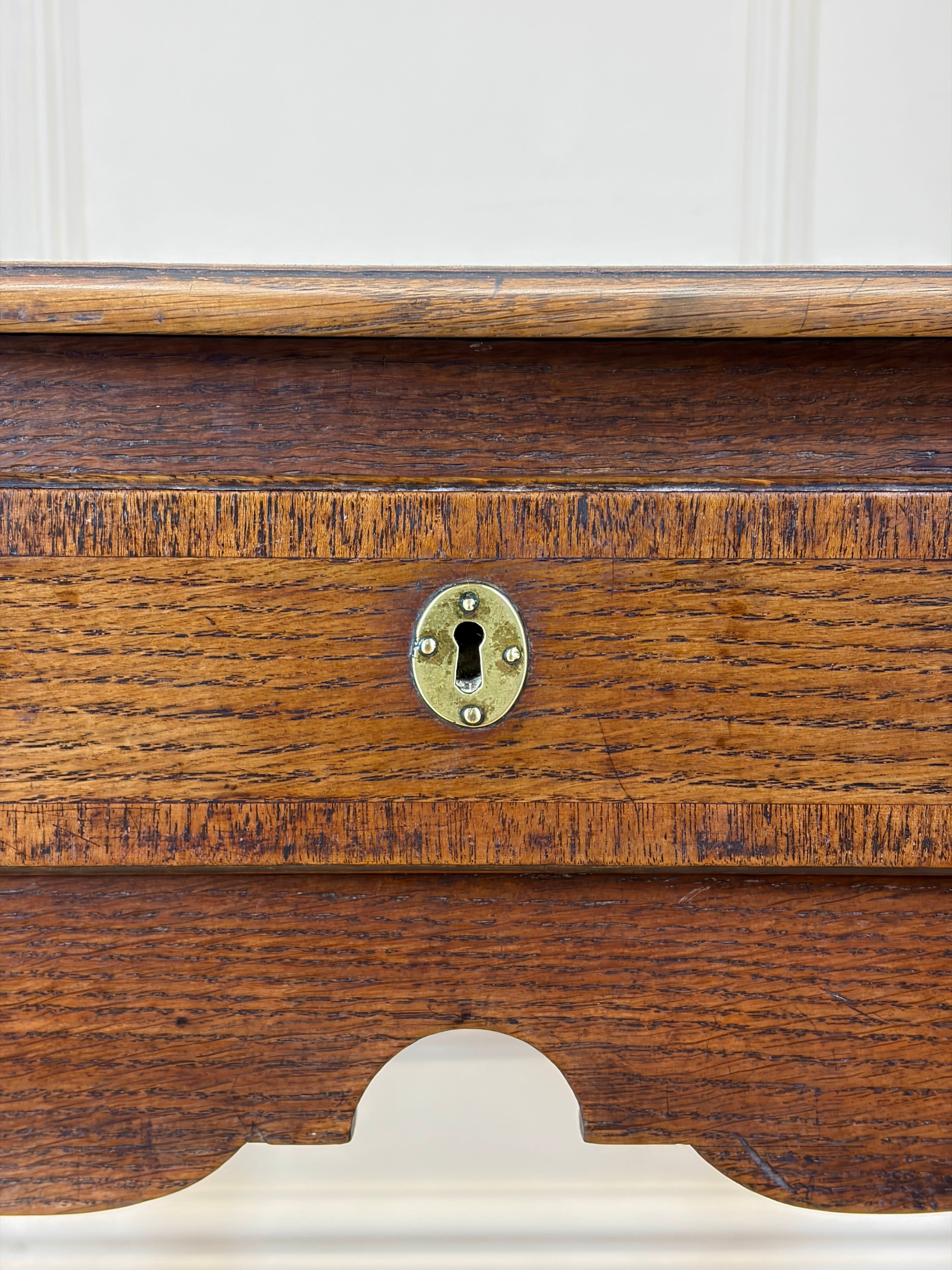 Close-up of a wooden drawer with a brass lock on a white background